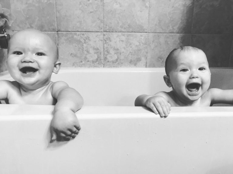 Twins Maverick and Harper laughing in bathtub